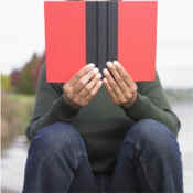 man with opened book in front of face