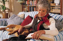 woman reading on couch with dog 
